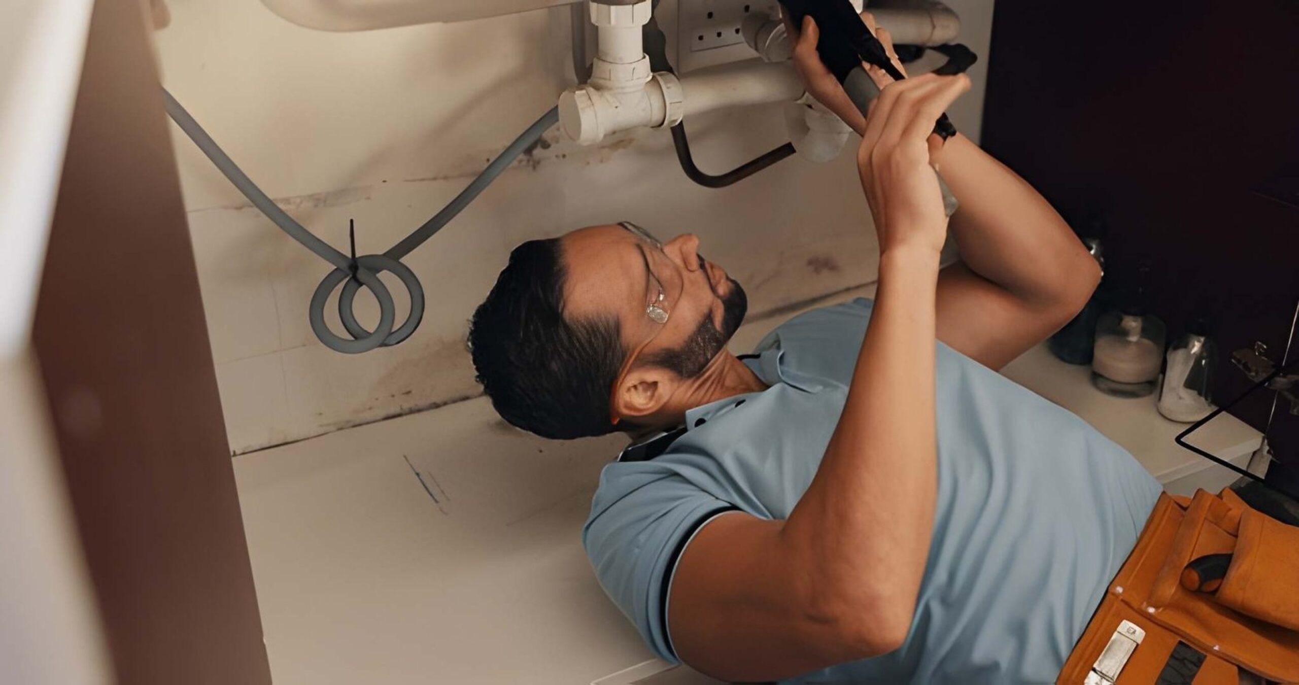 Plumber repairing a leaking pipe in a Dubai property